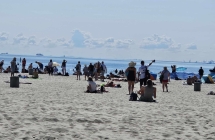 Ludzie na plaży, w tle żurawie w gdańsku